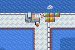 A tiled indoor floor with a machine, a computer terminal and a row of crates beside the player