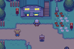 A town at night: a two-storey house with lit windows, red-and-white flower beds, a signpost and a small girl in the road