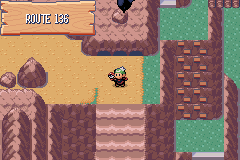 The player standing on Route 136, a canyon of red rock beside green ledges