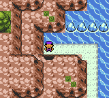 An overworld area of rocky cliffs and water inlets, a cluster of blue gems on a small island