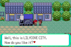 Two characters beside a moving van outside a row of blue-roofed houses; the text box reads "Well, this is LILYCOVE CITY. How do you like it?"