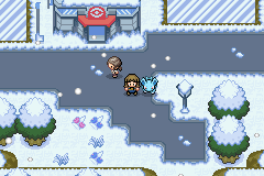 A snowy town with snow-covered trees and a Pokémon Centre, the player standing beside a Wooper in the falling snow